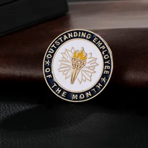 Macro shot of Outstanding Employee of the Month metal brooch with blue enamel and gold torch