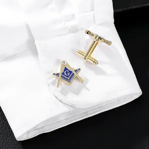 Close-up van gouden manchetknopen met blauw emaille vrijmetselaarslogo op shirt