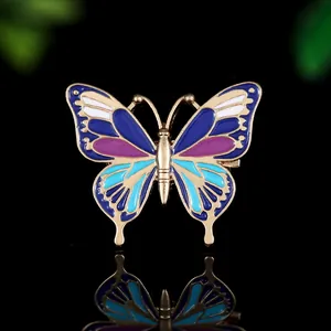 Macro de la broche papillon en émail coloré avec cadre doré sur fond noir élégant