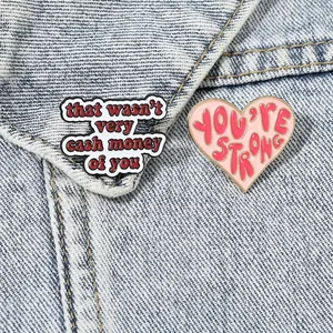 Enamel pin set with motivational quotes on a blue denim jacket background