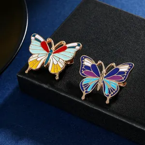 Gros plan détaillé de broches papillon en émail éclatant avec bords dorés métalliques fins