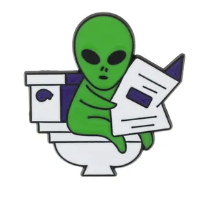Insigne amusant d'alien vert lisant un journal sur les toilettes pour cadeau d'Halloween