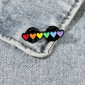 Rainbow heart enamel brooch pins on denim fabric with vibrant colors and double metal backing