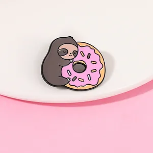 Détail de la broche en émail paresseux mignon tenant un donut rose avec pépites