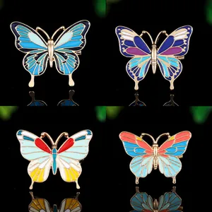 Détail de quatre broches papillon en émail coloré avec textures d'ailes complexes