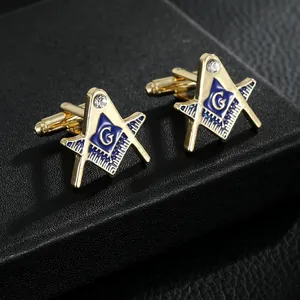 Macro detail van gouden vrijmetselaars manchetknopen met blauw email en kristal accent