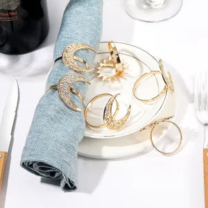 Detail view of golden celestial napkin rings with crescent moon and sunburst motifs
