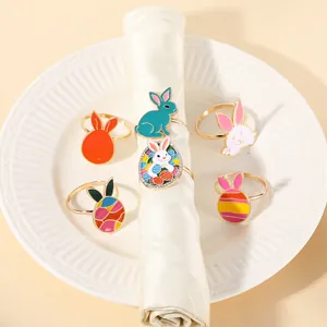Detail of colorful Easter bunny and egg metal napkin rings on a white ceramic plate