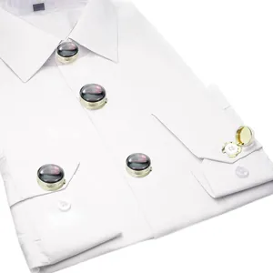 Detail of round gold-plated button covers with iridescent finish on a white dress shirt
