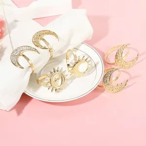 Detail of golden moon and sun napkin rings with intricate star patterns and crystal accents
