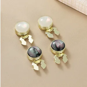 Detailed macro view of elegant gold-plated cufflink studs with pearl and iridescent inlays