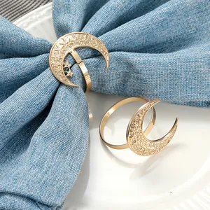 Golden moon and star napkin rings set on navy blue cloth for holiday dining decor
