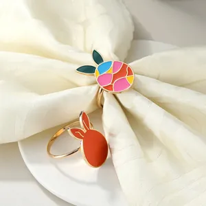 Colorful mosaic and orange metal bunny napkin rings on white fabric for Easter dining