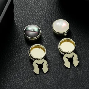 Gold-plated French cufflinks with mother-of-pearl inlay on black leather background