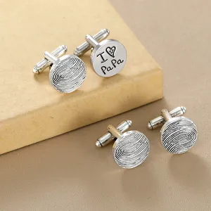 Detailed view of silver cuff links with fingerprint texture and I Love Papa engraving