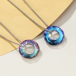 Close-up of faceted crystal circle pendants in deep blue and iridescent gradient colors