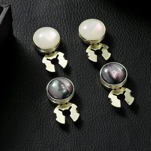 Detail view of gold cufflinks with mother-of-pearl and iridescent grey inlay on black leather