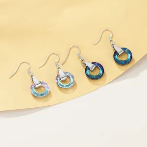 Detail showing two pairs of multifaceted crystal drop earrings in blue and purple gradients