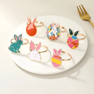 Detailed view of assorted colorful Easter bunny and enamel egg metal napkin rings on a plate