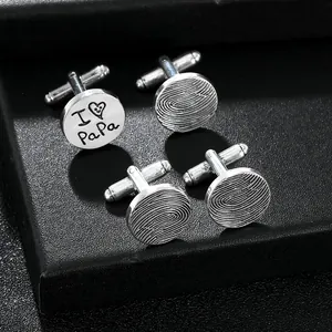 Detailed macro of silver cufflinks featuring I Love PaPa engraving and fingerprint textures