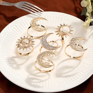 Detailed set of six golden sun and moon napkin rings with rhinestones on a ceramic plate