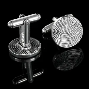 Silver cufflinks for men's shirts featuring a round textured fingerprint pattern design