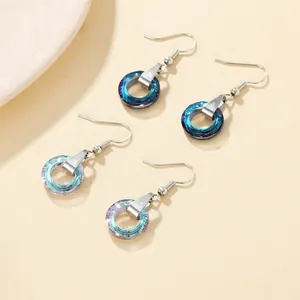 Detail view of crystal hoop earrings with blue gradient faceted stones and silver hooks