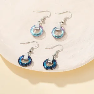 Detailed macro view of faceted gradient crystal hoop earrings with silver metal hooks