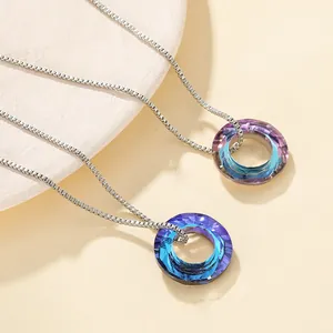 Close-up of circular crystal pendants with blue and purple gradient on box chains