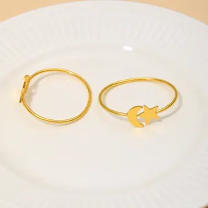Goldene Serviettenringe mit Mond und Stern auf einem dekorativen weißen Keramikteller