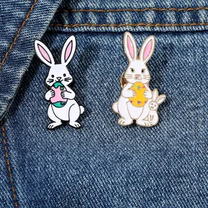 Primer plano de broches de conejo esmaltados con huevos de Pascua sobre tela vaquera