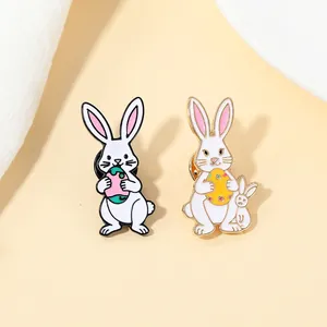Detalle de broches de conejitos de Pascua en esmalte con huevos de colores y oro