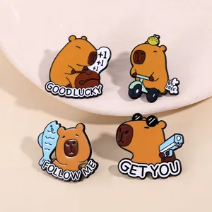 Détail de quatre épingles en émail Capybara aux poses ludiques dans un plat en céramique