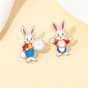 Detalle de broches esmaltados conejo reloj con marcos dorados y acabado en laca blanca