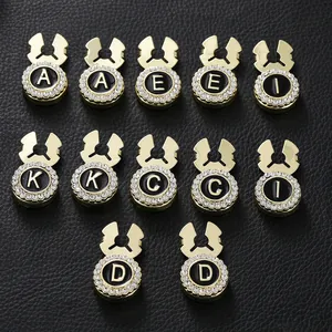 Detailed macro view of gold-plated cufflinks with black enamel letters and rhinestones