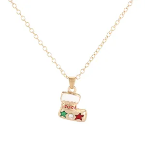 Golden Christmas stocking pendant necklace with white glaze and star accents