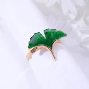 Détail du rond de serviette en forme de feuille de ginkgo dorée avec émail vert poli