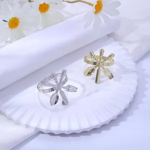 Gros plan de ronds de serviette en métal doré et argenté sur une assiette blanche