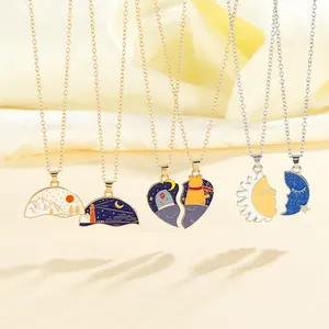 Detailed view of enamel couple necklaces with sun, moon, and landscape scenery pendants