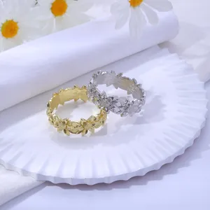 Détail de ronds de serviette tournesol en argent et or sur une assiette avec fleurs