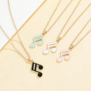 Close-up of music note pendant necklaces in gold alloy with colorful enamel details