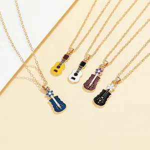 Close-up of violin and guitar pendants with colorful enamel details and golden chains
