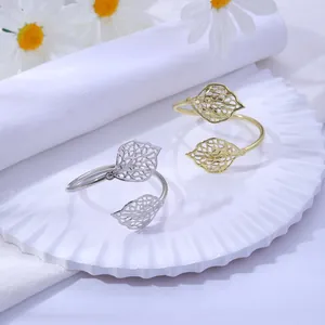 Gros plan de ronds de serviette en forme de feuilles dorées et argentées sur assiette