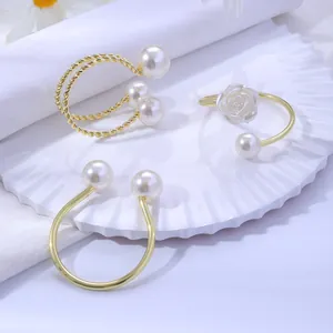 Détail de ronds de serviette dorés avec des perles blanches élégantes et motifs floraux