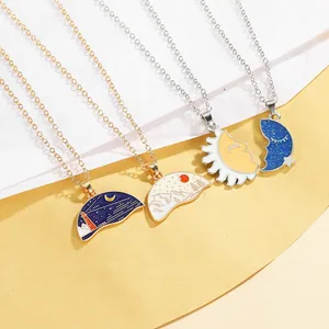 Close-up of colorful enamel lighthouse and mountain pendants on gold necklaces