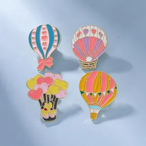 Lot de quatre pin's émaillés en forme de montgolfière cœur avec bordure dorée en alliage de zinc