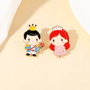 Detailansicht der Emaille-Pins mit Cartoon-Prinz und Prinzessin und goldenen Linien