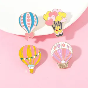 Vue détaillée de quatre broches en émail en forme de montgolfière sur une assiette blanche