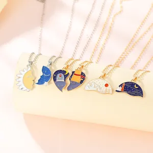 Close-up of assorted enamel pendants featuring sun, moon, and cat motifs on chains