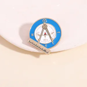 Macro shot of creative compass and ruler badge in blue and white enamel with gold trim